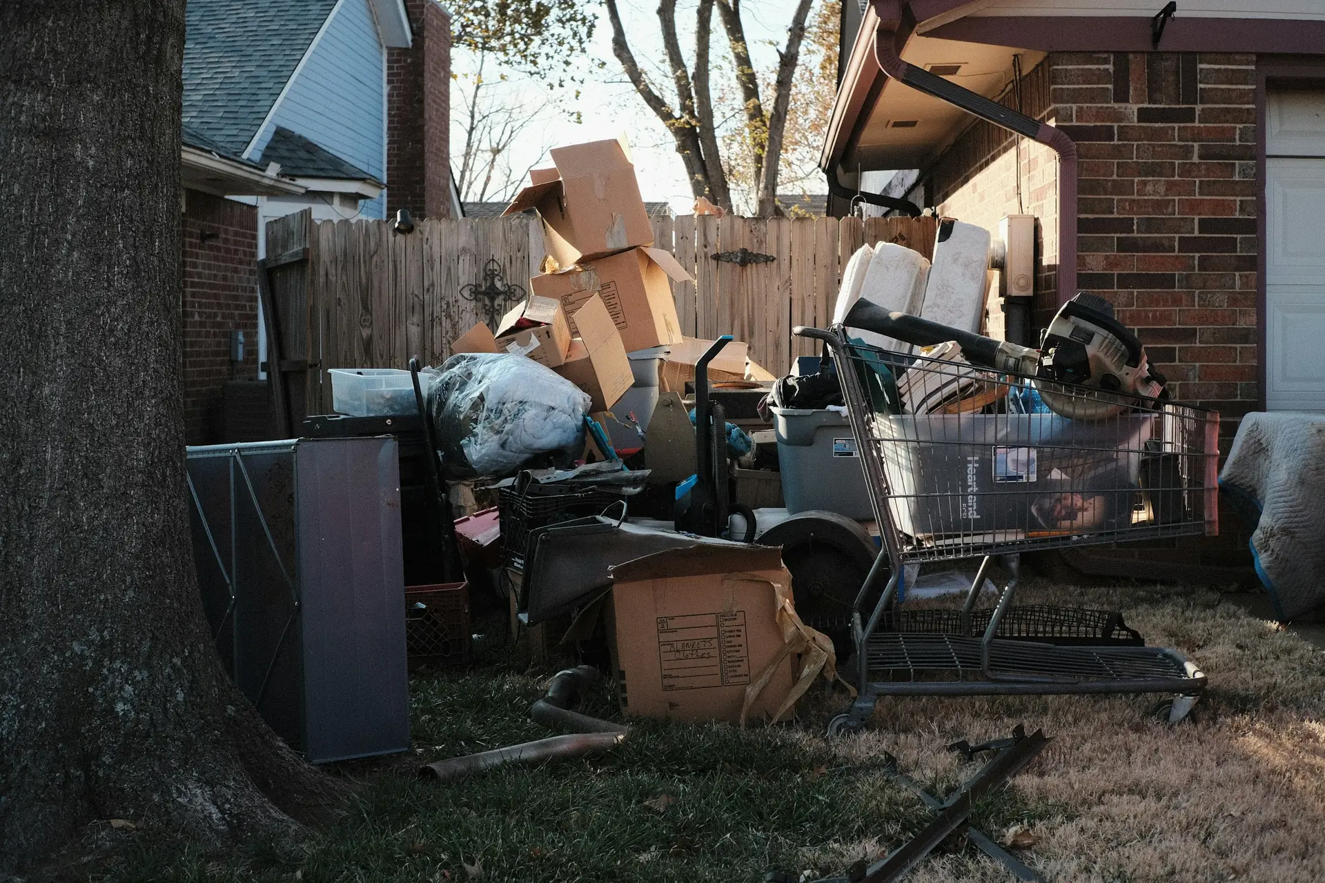 A pile of boxes, furniture and junk in a backyard