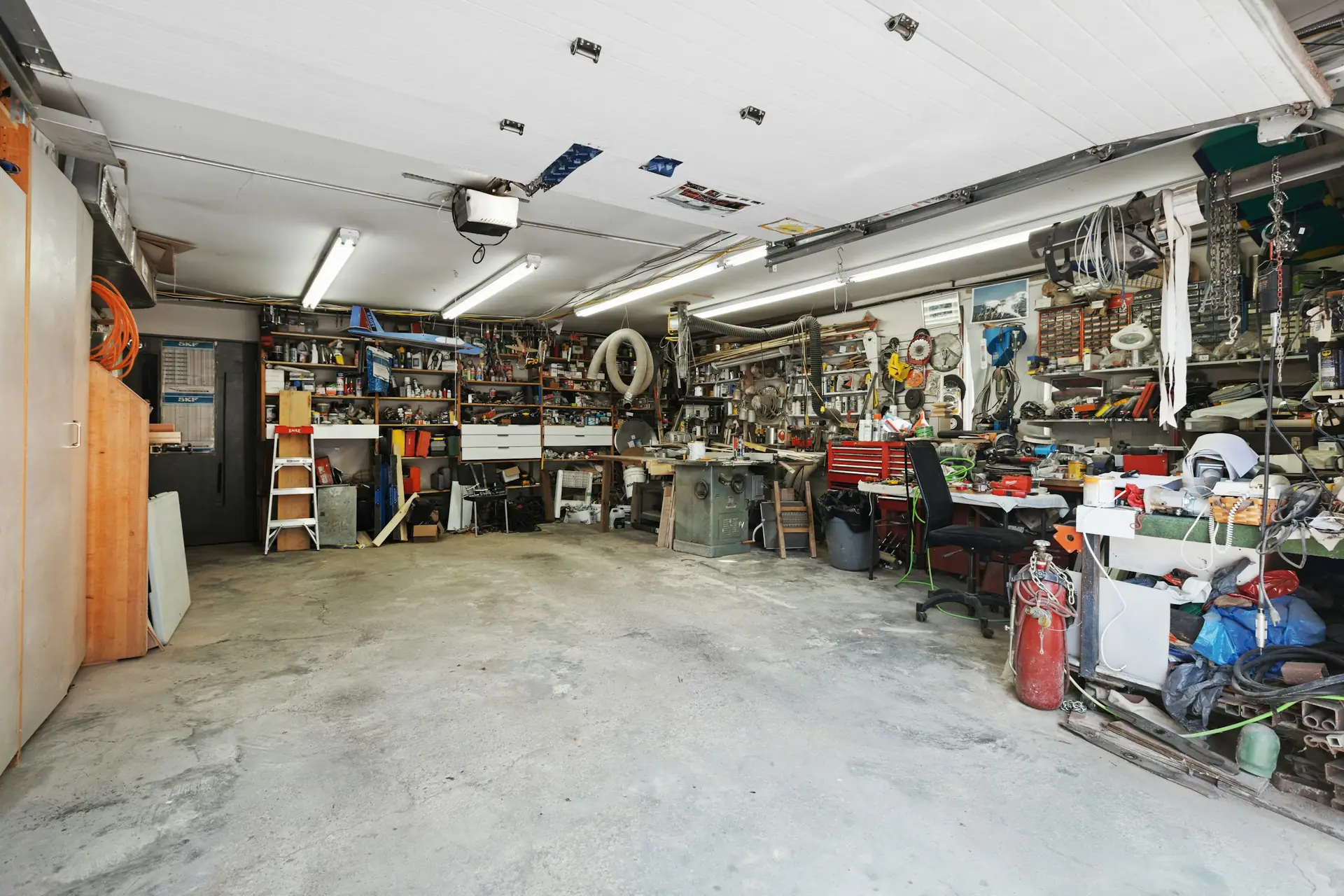 A garage packed with tools, shelving and clutter